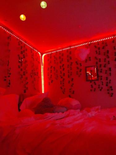 Habitación roja con cama con luces rojas en SpicyGameRoom en La Paz