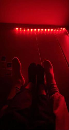 un grupo de personas sentadas en una habitación con luces rojas en SpicyGameRoom en La Paz