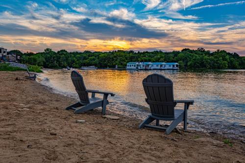 dos sillas sentadas en una playa cerca de un cuerpo de agua en Four Corners RV Resort, en Antioch