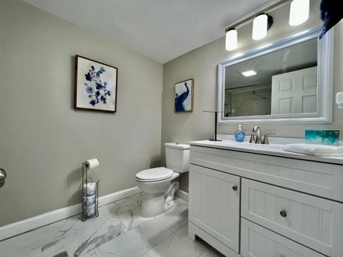 a white bathroom with a toilet and a sink at 7086 Tylersville Beautiful 4 BDR Home - Near I-75 in Maud