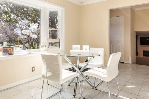a dining room with a glass table and white chairs at 5 bedrooms with 4 Full Bath Fire Pit BBQ and Plush Amen on 1 2 acre in Silver Spring