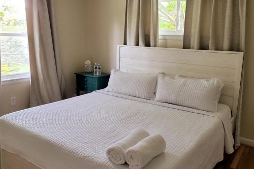a white bed with two towels on top of it at 5 bedrooms with 4 Full Bath Fire Pit BBQ and Plush Amen on 1 2 acre in Silver Spring