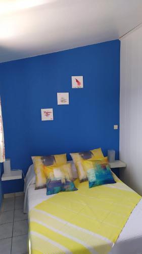 - une chambre dotée d'un mur bleu et d'un lit avec des oreillers dans l'établissement Le panoramique, à Bendéjun