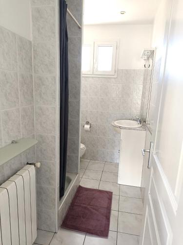 une salle de bain avec un lavabo et une douche dans l'établissement Le panoramique, à Bendéjun