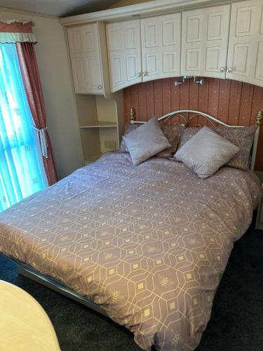 a bedroom with a bed with a wooden headboard at Hideout caravan in Llangristiolus