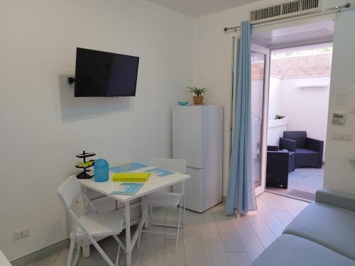 a living room with a white table and a tv at SoleMare Rooms "Acquamarina" in Procida