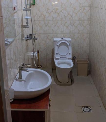 a bathroom with a white toilet and a sink at Royal villas in Ruhengeri