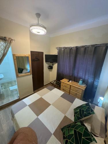 a bedroom with a bed and a checkered floor at El Conde De Atrini in Santo Domingo