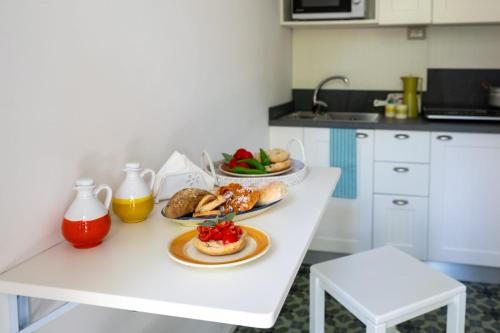 un tavolo bianco con due piatti di cibo sopra di B&B Lu Cuccuviu a Mare a San Foca