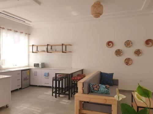 ein Wohnzimmer mit einem Sofa und einer Küche in der Unterkunft Cultural Haven in Kigali, Rwanda in Kigali
