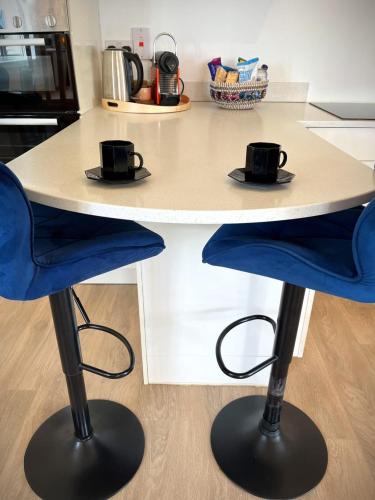 a kitchen counter with two chairs and a table at The Gate House, Kilmullen in Portarlington