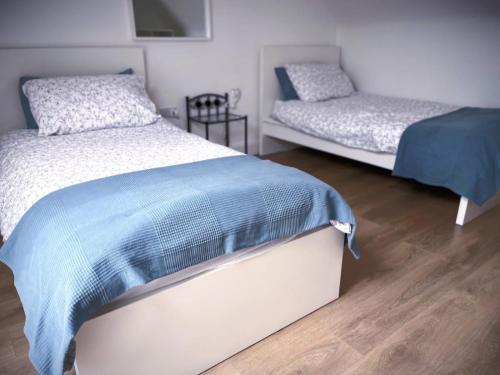 1 dormitorio con 2 camas y suelo de madera en The Gate House, Kilmullen en Portarlington
