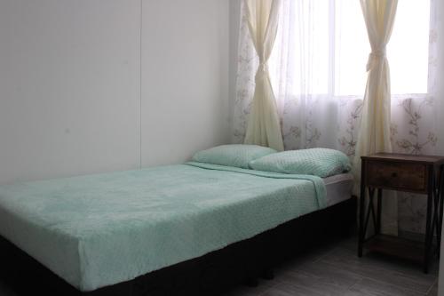 ein kleines Schlafzimmer mit einem Bett und einem Fenster in der Unterkunft HERMOSO APTO EN CLUB HOUSE- RICAURTE CUNDINAMARCA in Ricaurte
