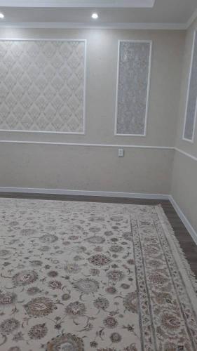 an empty room with a rug and two windows at ElSAR guesthouse in Osh