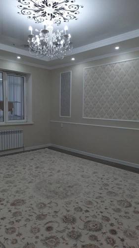 una grande stanza vuota con un lampadario in una stanza di ElSAR guesthouse a Oš