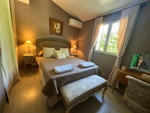 ein Schlafzimmer mit einem Bett mit zwei Kissen und einem Fenster in der Unterkunft Central Valbonne Villa in Valbonne