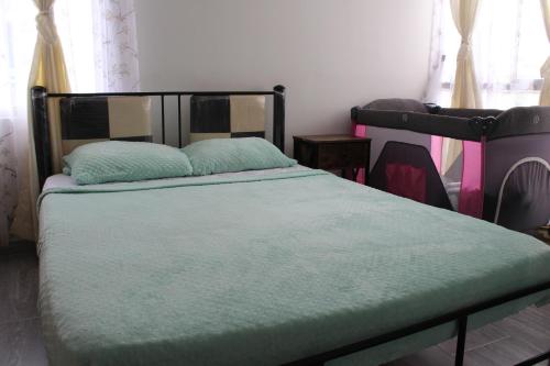 ein Schlafzimmer mit einem Bett mit einer grünen Bettdecke in der Unterkunft HERMOSO APTO EN CLUB HOUSE- RICAURTE CUNDINAMARCA in Ricaurte