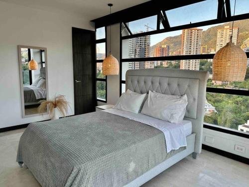 - une chambre avec un grand lit et de grandes fenêtres dans l'établissement 2001 Charming apartment in El Poblado, à Medellín