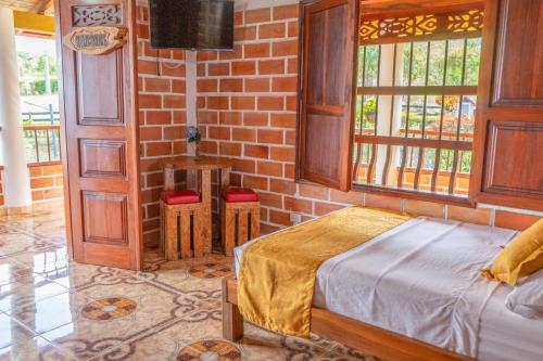 a bedroom with a bed and a brick wall at Acantos Hotel Campestre in Támesis