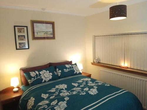 um quarto com uma cama com um cobertor azul e branco em Inviting 3-Bed Apartment in Walsall em Walsall