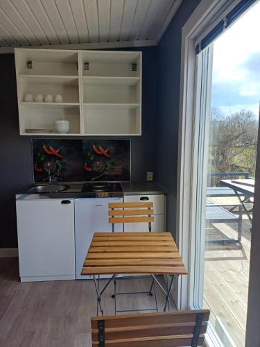 a kitchen with a wooden table and a counter at Klinta sea view 2 in Köpingsvik