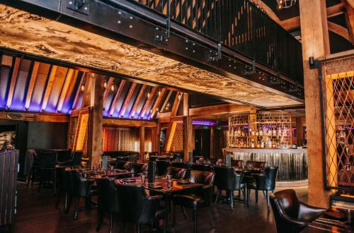 a restaurant with tables and chairs in a room with wine racks at Cave Hotel & Golf Resort in Faversham