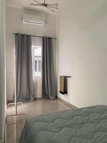 1 dormitorio con 1 cama y una ventana con cortinas en Homestay Taman Melati Jerantut, en Jerantut