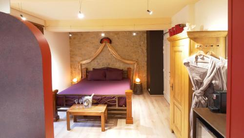 a bedroom with a large bed and a table at Domaine et chambres d'Hôtes des Fées in Pretin