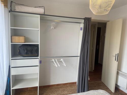 - un placard avec une porte en verre dans la chambre dans l'établissement La coquille - Appartement spacieux 45m2, T2 à 1min de la plage - WIFI, à Valras-Plage