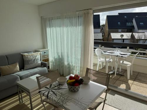 un soggiorno con un divano e un tavolo di Confortable studio, wifi, parking, proche plage a Carnac