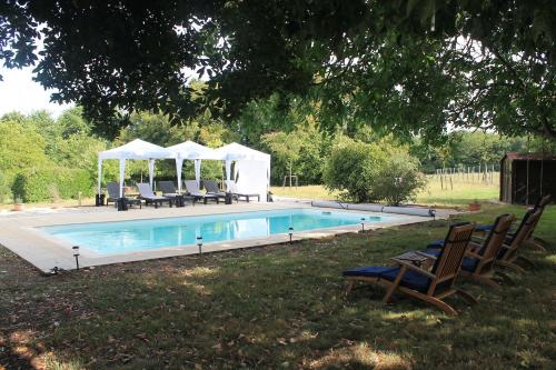 een zwembad met stoelen en een prieel bij Cha16 - Nanteuil En Vallee - Touchbaudrand in Messeux