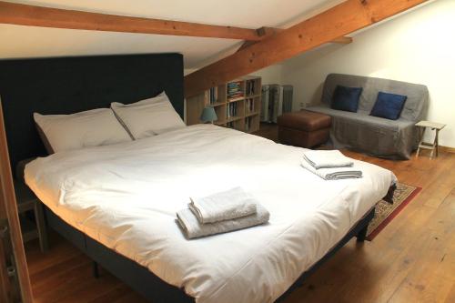 een slaapkamer met een groot wit bed en een stoel bij Cha16 - Nanteuil En Vallee - Touchbaudrand in Messeux