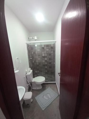 a bathroom with two toilets and a shower stall at Pousada Pé Na Areia in Arraial do Cabo