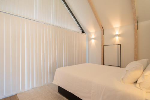 a bedroom with a white bed and a large window at FONTE SANTA Manor House in Vila Nova de Gaia