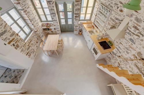 um quarto com uma parede de tijolos, uma mesa e cadeiras em ArtdecoSyros Superior em Ano Syros
