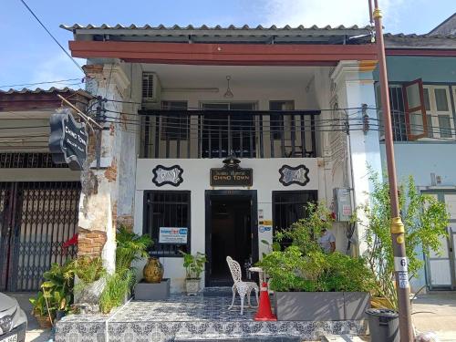a building with a balcony and two chairs in front of it at Chino Town Gallery Alley - SHA Plus in Phuket Town