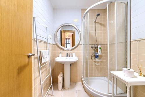 a bathroom with a shower and a sink and a mirror at Acogedor y Elegante Apartamento en Irala in Bilbao
