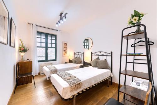a bedroom with two beds and a ladder at Acogedor y Elegante Apartamento en Irala in Bilbao