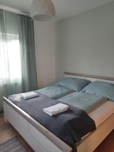 a bedroom with a large bed with two towels on it at Gönyüi álom kuckó in Gönyů