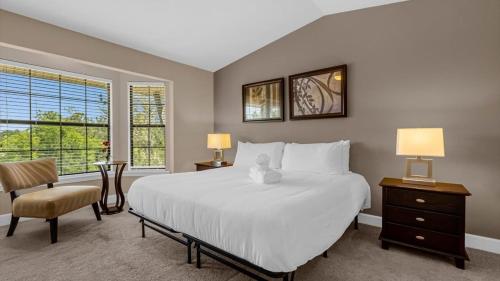 a bedroom with a large white bed and a chair at Florida Getaway - Renovated TownHome by Disney! in Orlando