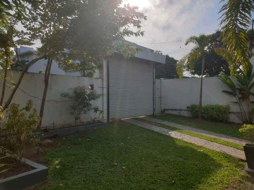 a house with a fence and a yard at Vidushi Home in Minuwangoda