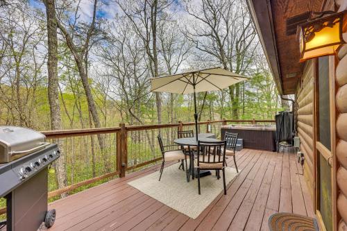 a deck with a table and chairs and an umbrella at Cozy Cabin in Private Location with Hot Tub and Grill! in Blue Ridge