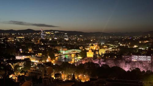 Una vista de una ciudad de noche con luces. en TbilApartments, en Tiflis