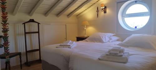 a bedroom with a large white bed with a window at Quinta da Soneca in Alandroal