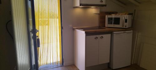 a small kitchen with a microwave and a refrigerator at Quinta da Soneca in Alandroal