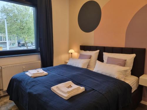 a bedroom with a bed with two towels on it at maremar - Design im Zentrum - Luxus Boxspringbetten - Arbeitsplätze & Highspeed WLAN - Balkon in Braunschweig