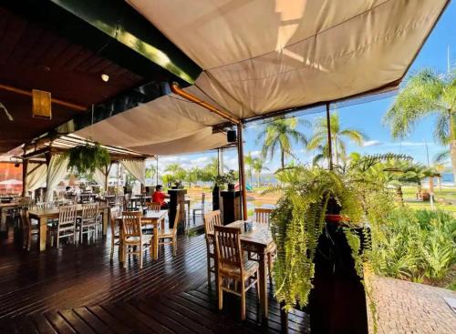 a restaurant with tables and chairs on a deck at View467LifeResortBR in Brasilia