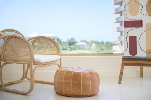 two chairs and a ottoman in a room with a window at Kailoa Villa in Long Bay Hills