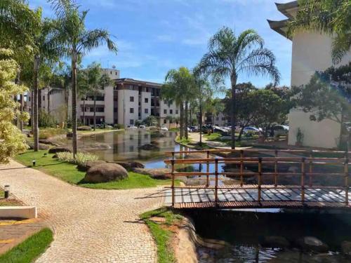 a bridge over a river with buildings and palm trees at View467LifeResortBR in Brasilia
