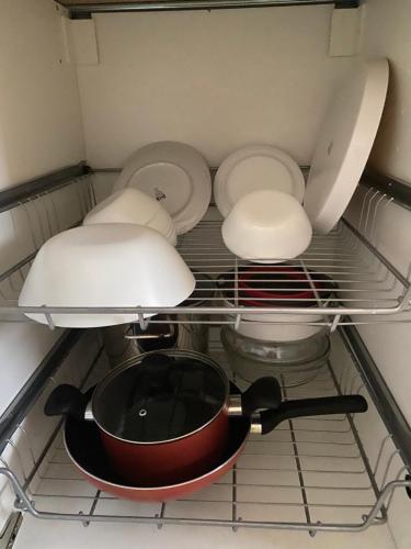 a shelf in a kitchen with a pot and pans at Homestay Taman Melati Jerantut in Jerantut